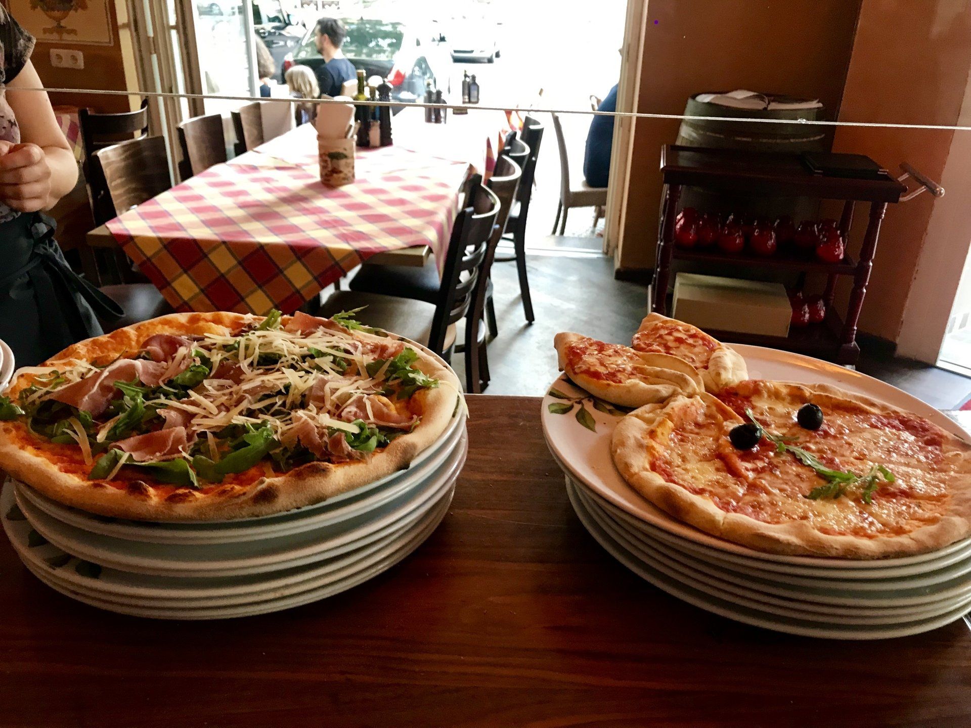 Zwei Pizzen liegen auf einem Holztisch in einem Restaurant