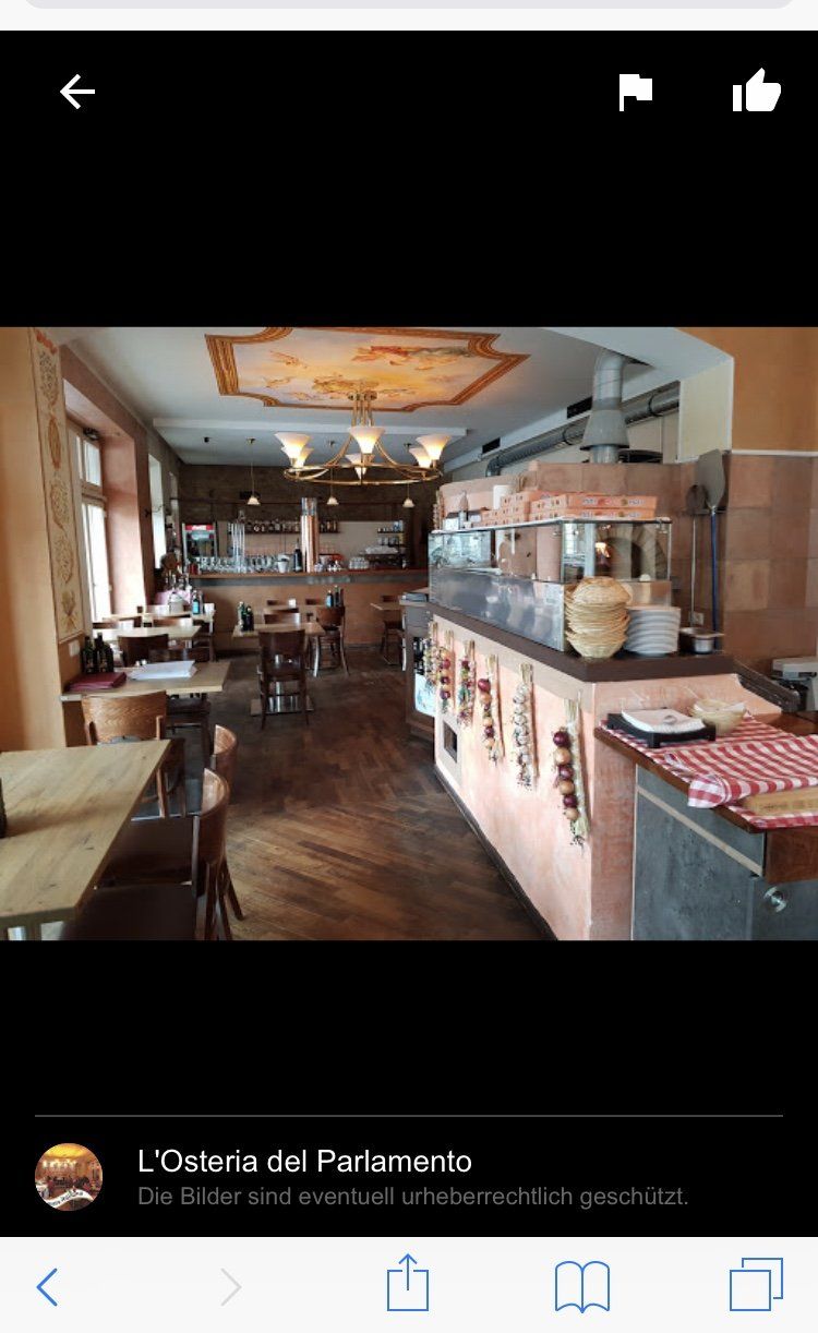 Ein Bild eines Restaurants mit Tischen und Stühlen auf einem Mobiltelefon.