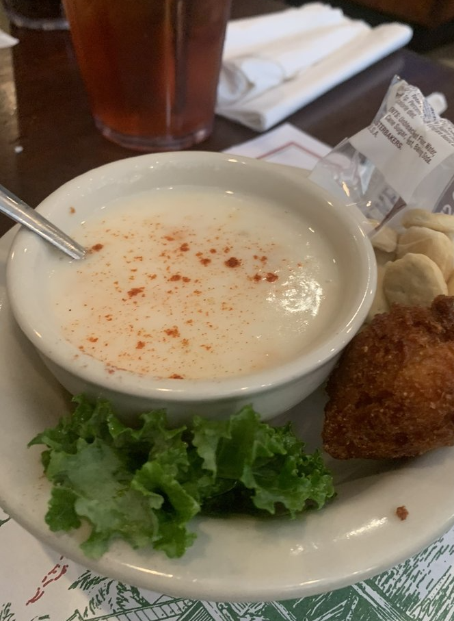 A bowl of soup and a plate of food on a table.