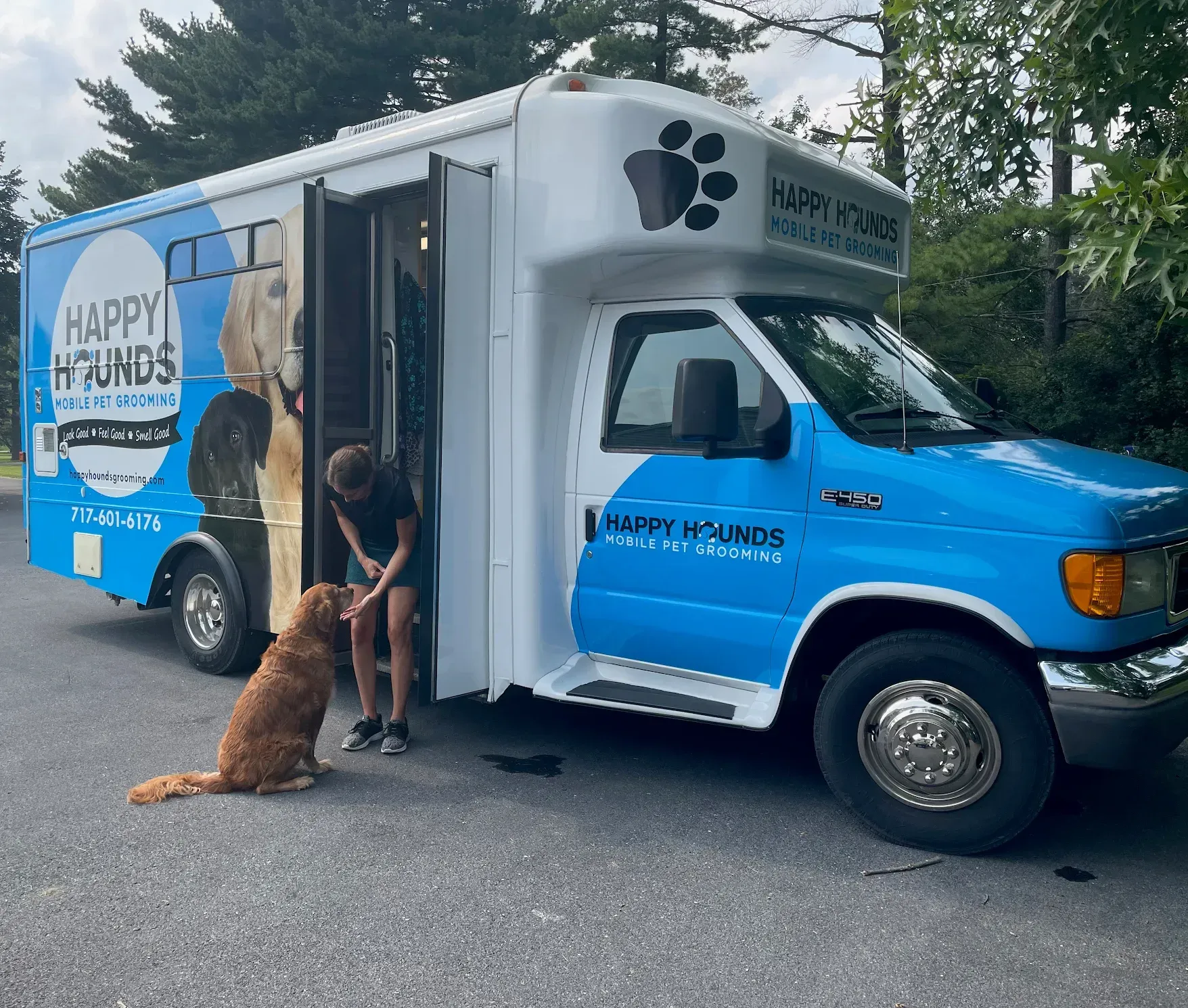 A blue and white van that says happy hounds on it