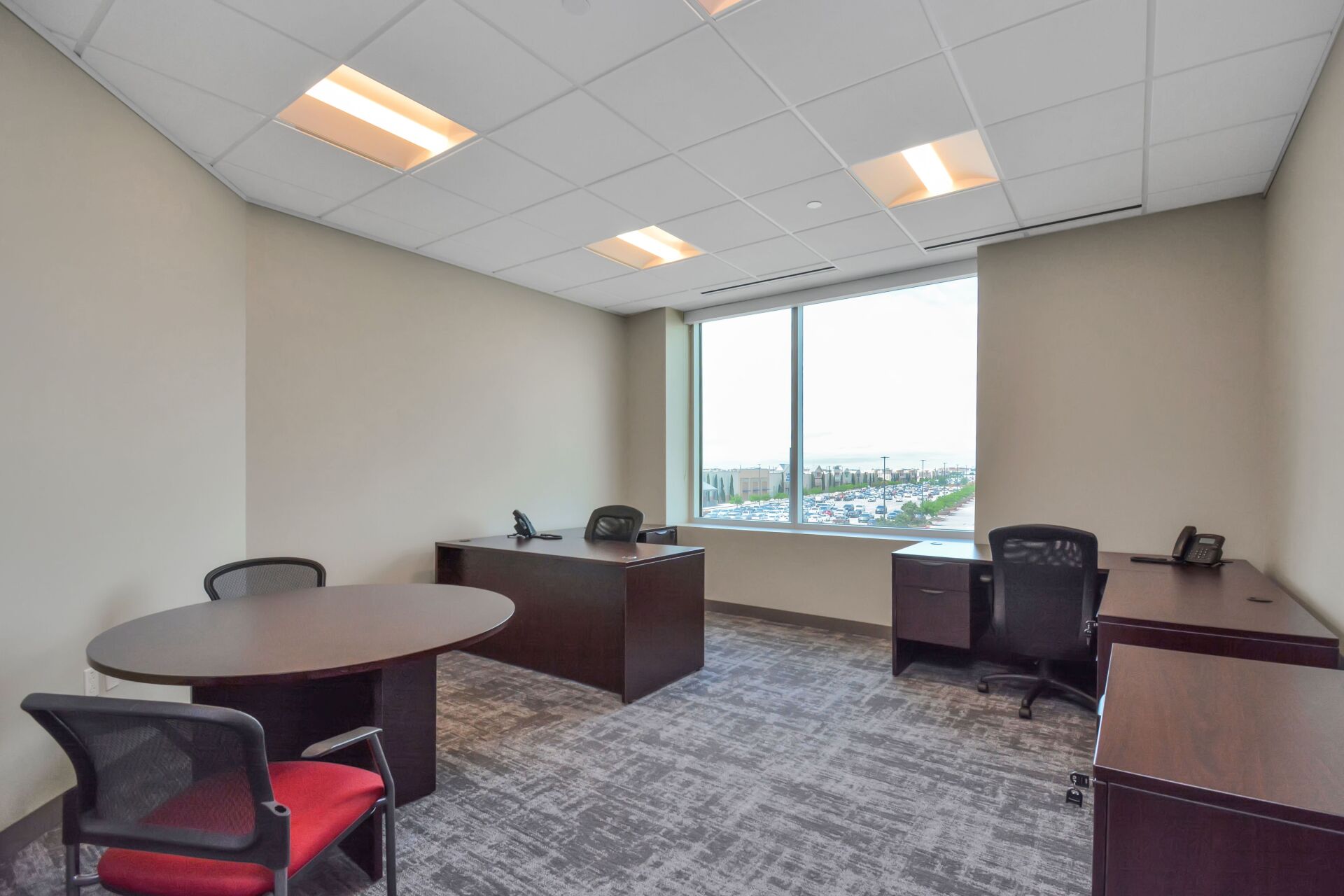 A small office with a table and chairs and a large window.