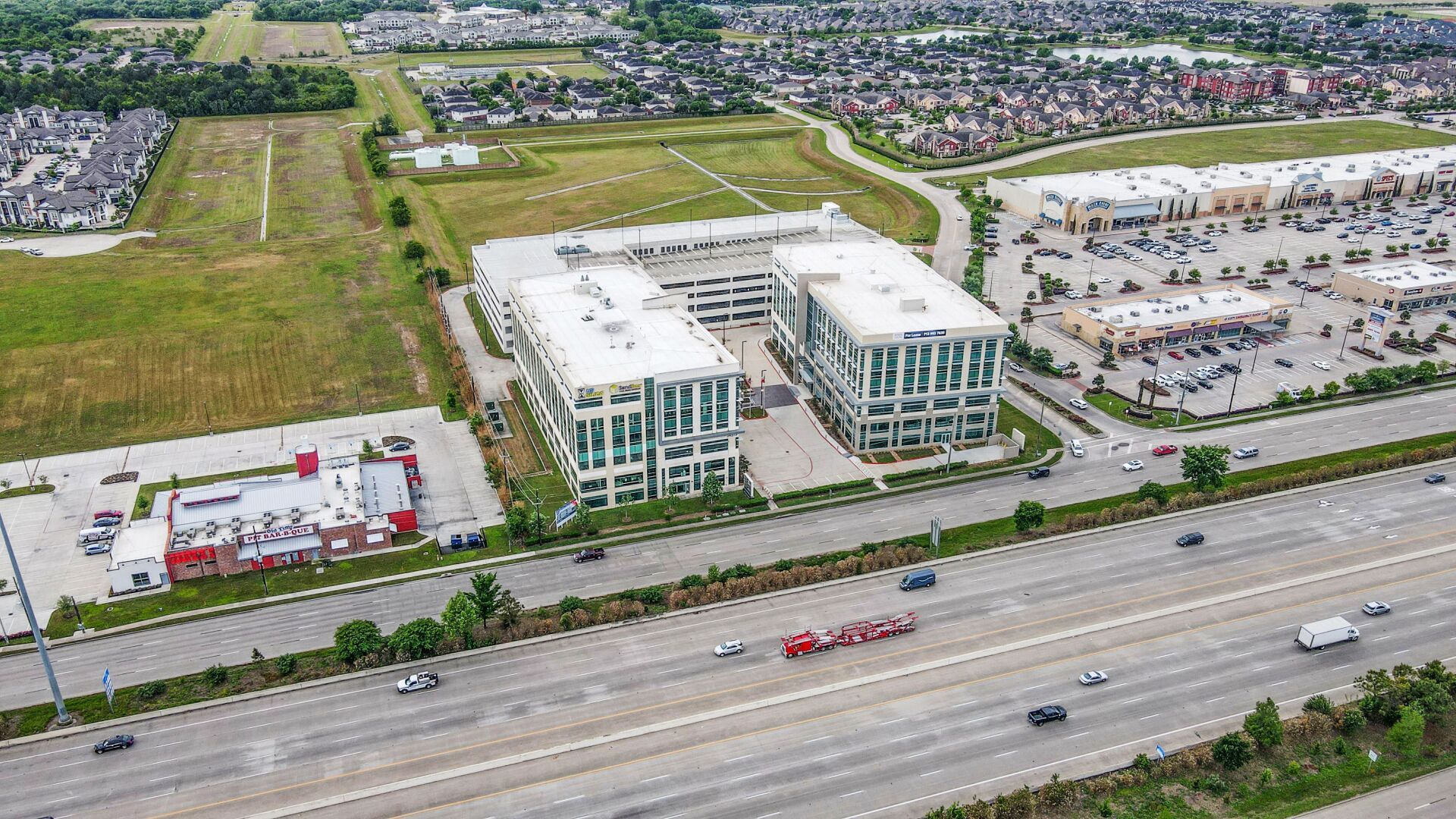 An aerial view of a large building next to a highway.