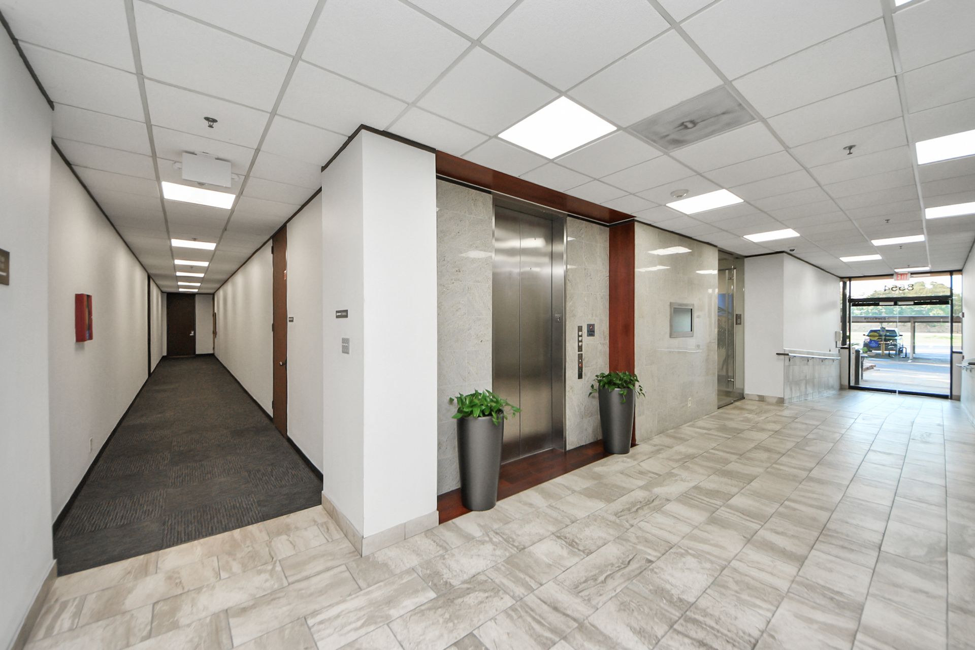 A small office with a desk , chairs and a window.