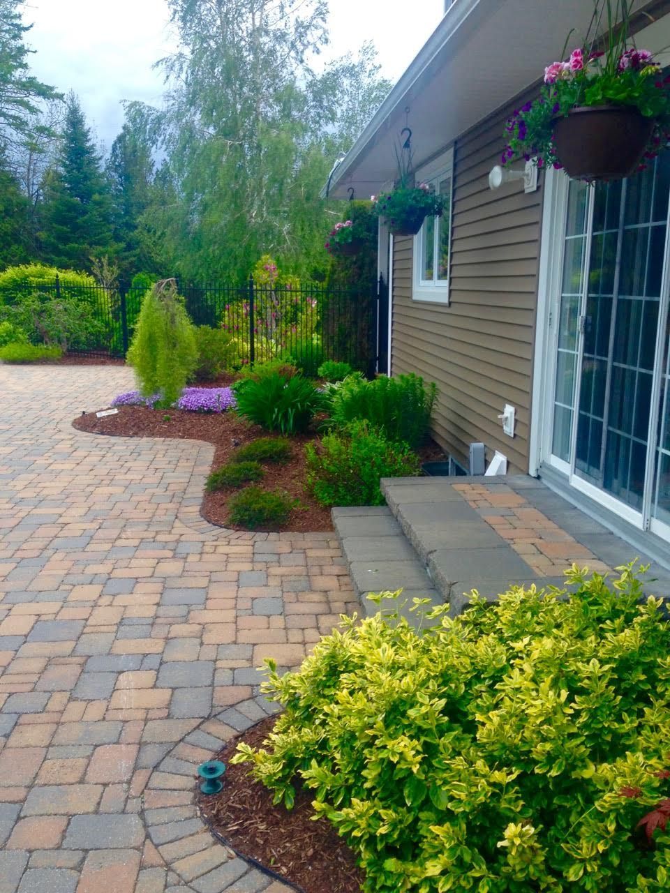 A house with a brick driveway and a sliding glass door