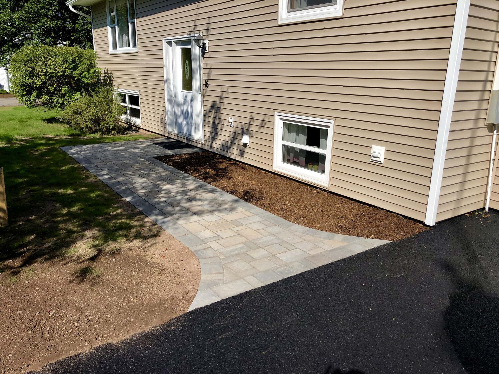 A house with a walkway leading to the front door.