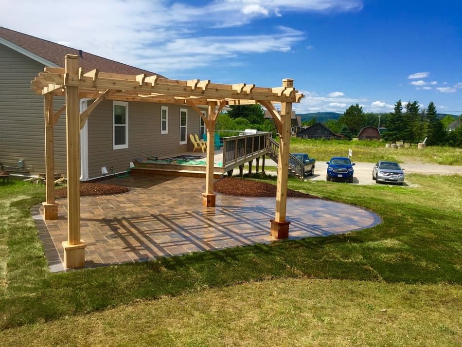 There is a pergola in the backyard of a house.