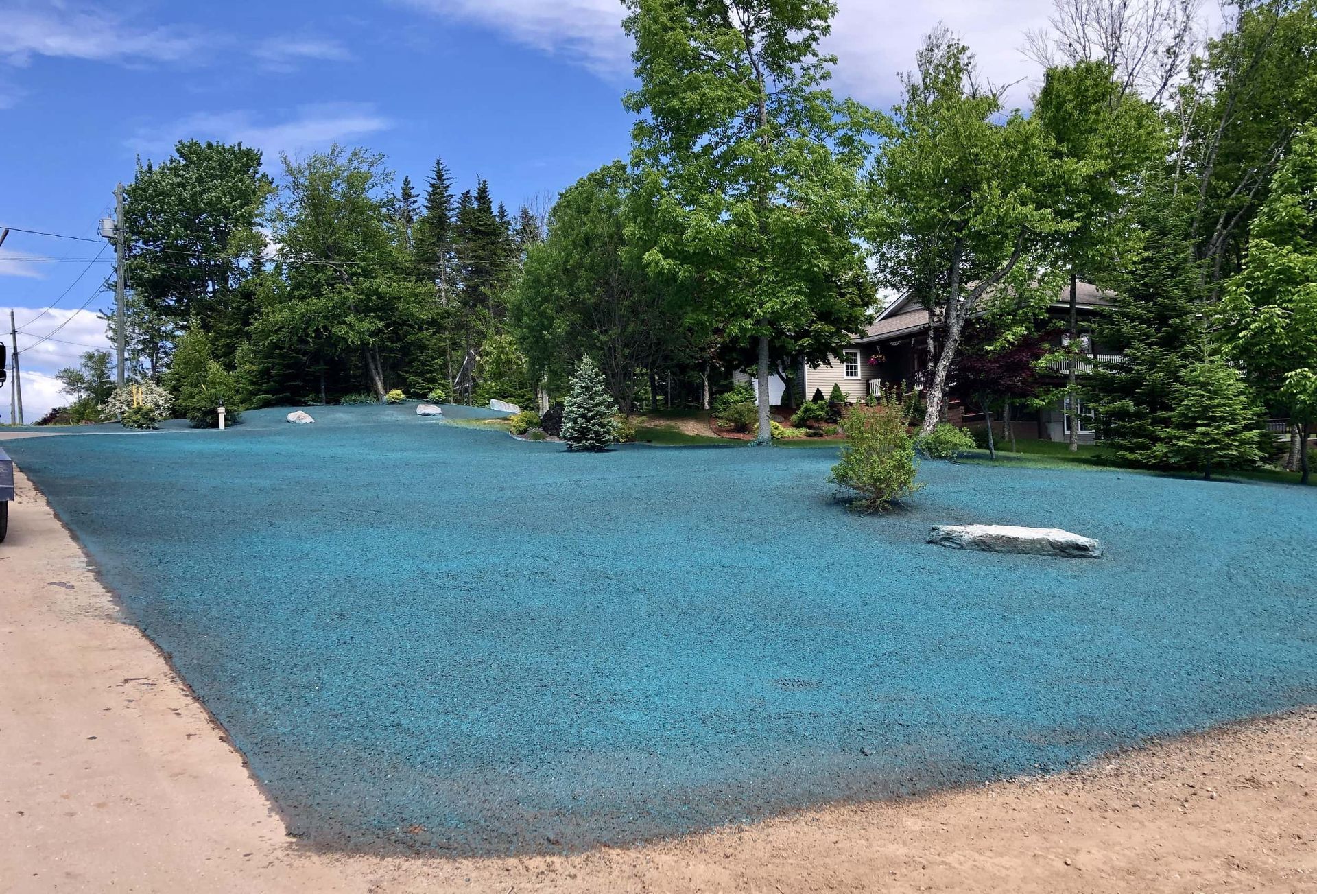 A lawn with a lot of green grass and trees in the background.