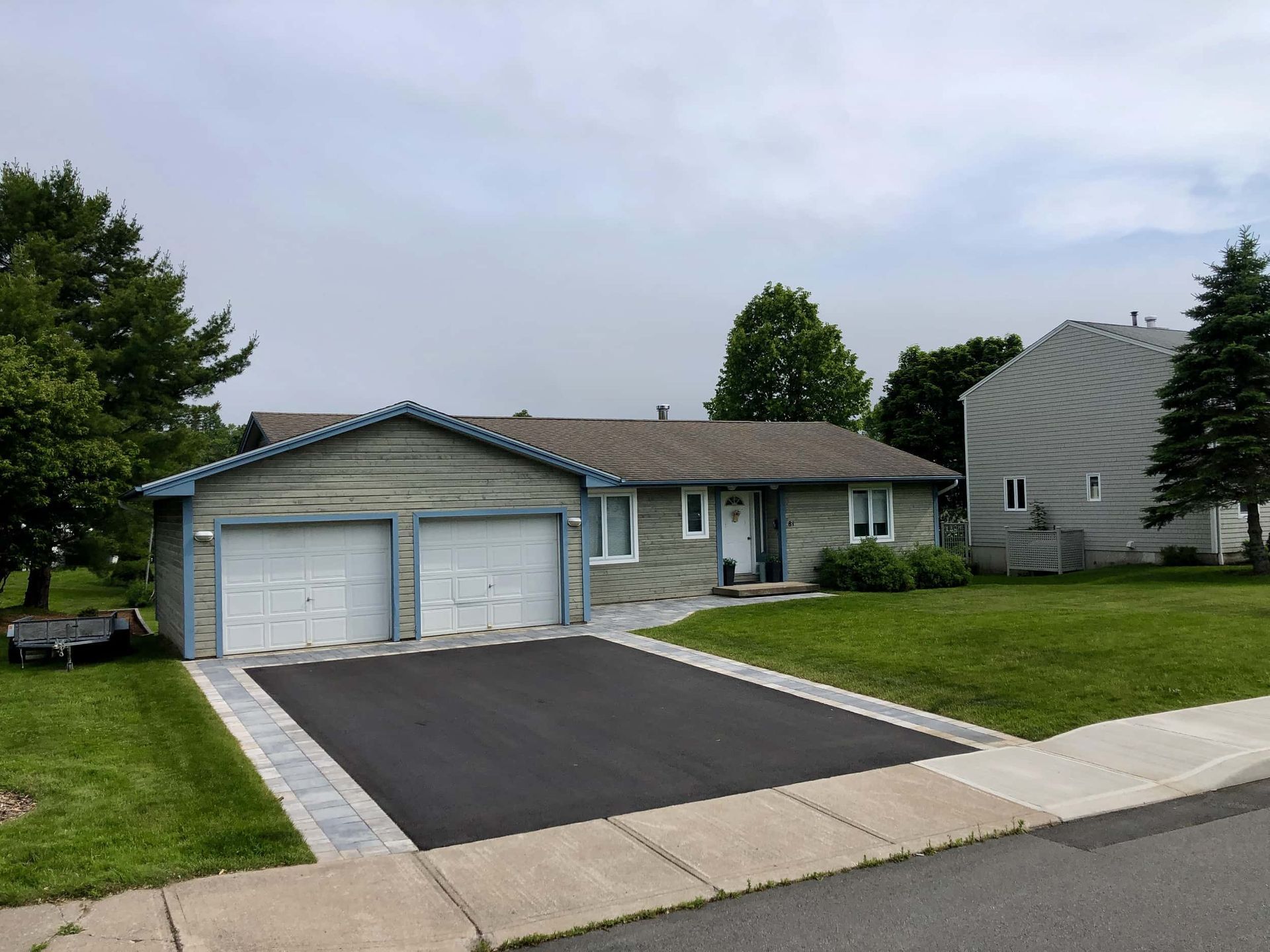 A house with two garage doors and a driveway in front of it
