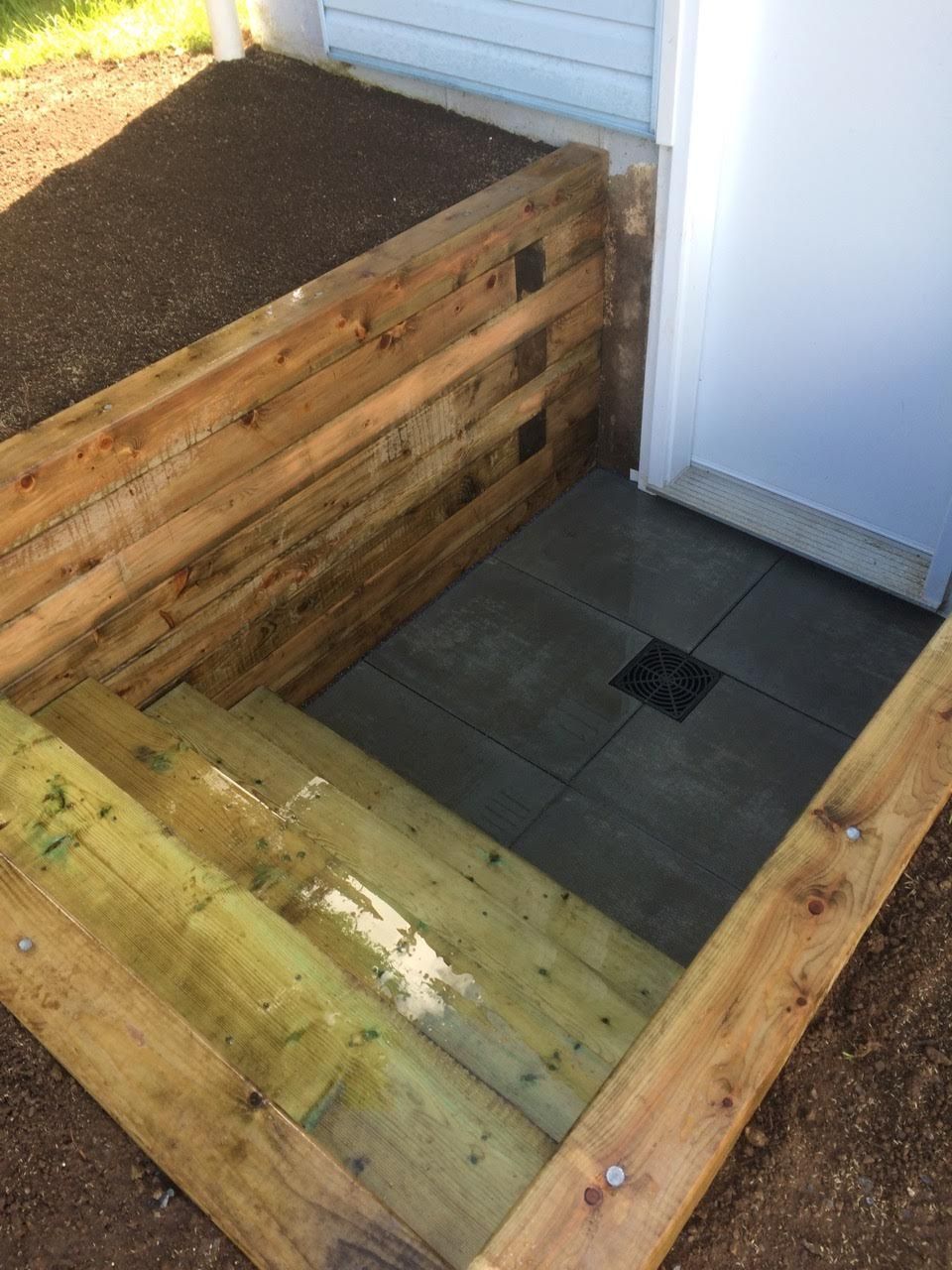 A wooden box with stairs leading up to a doorway.