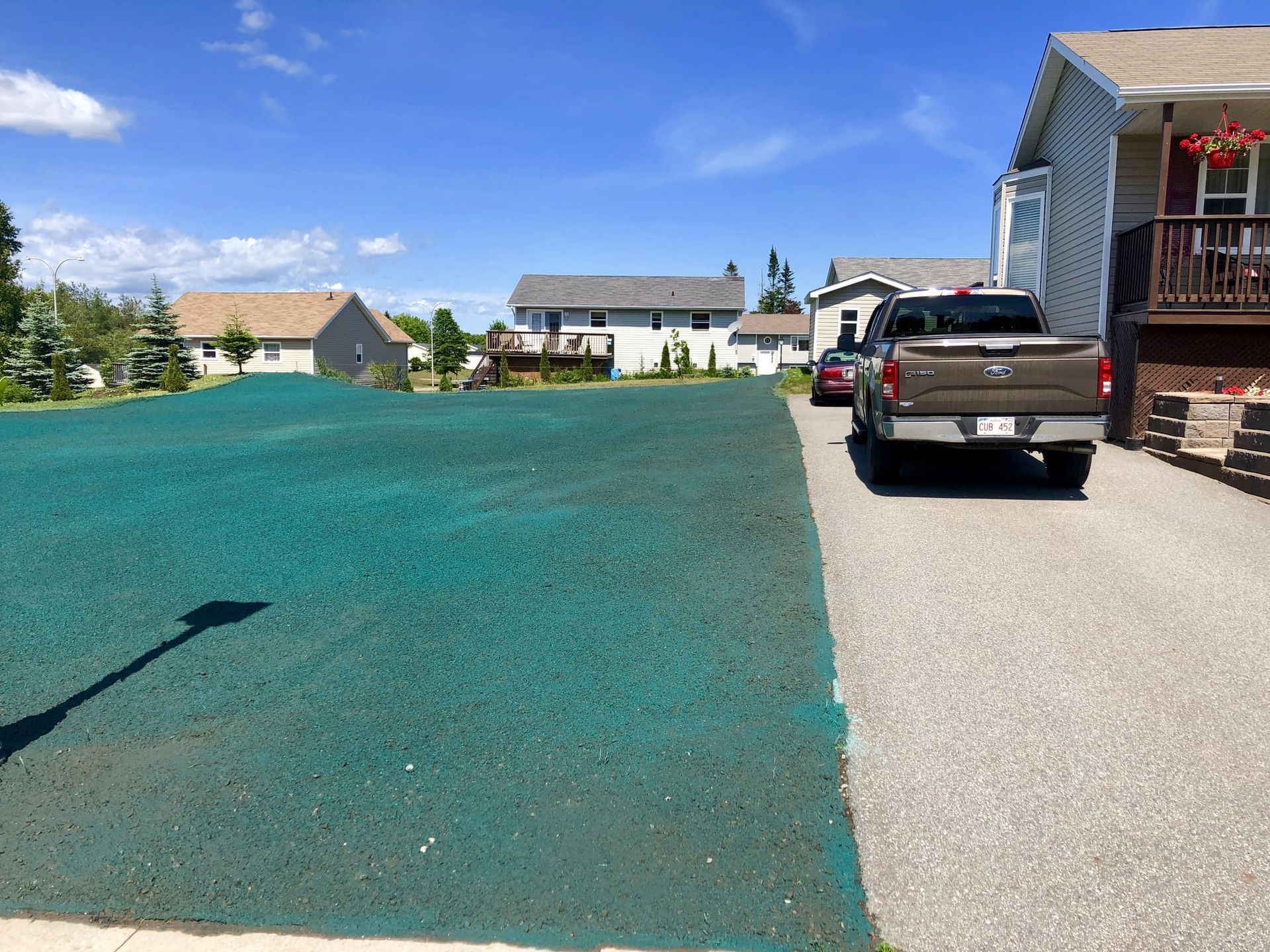 A truck is parked in a driveway next to a house.