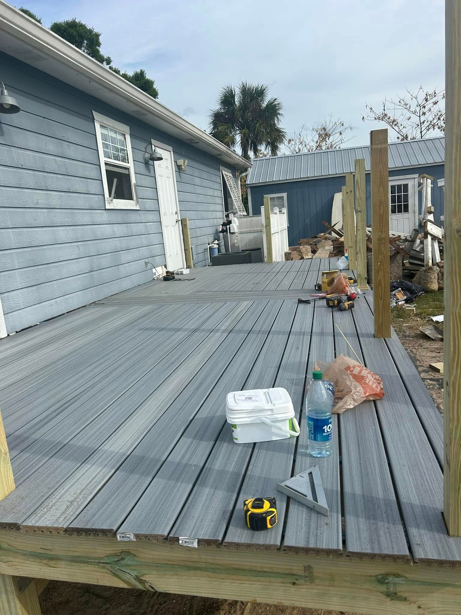 A wooden deck is being built in front of a house.