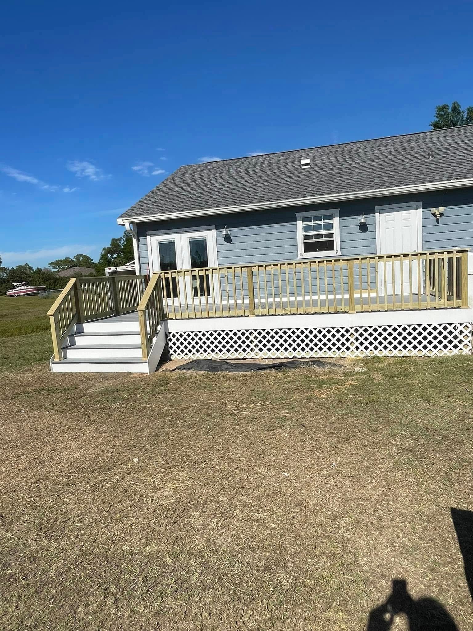 A house with a deck and stairs in front of it.