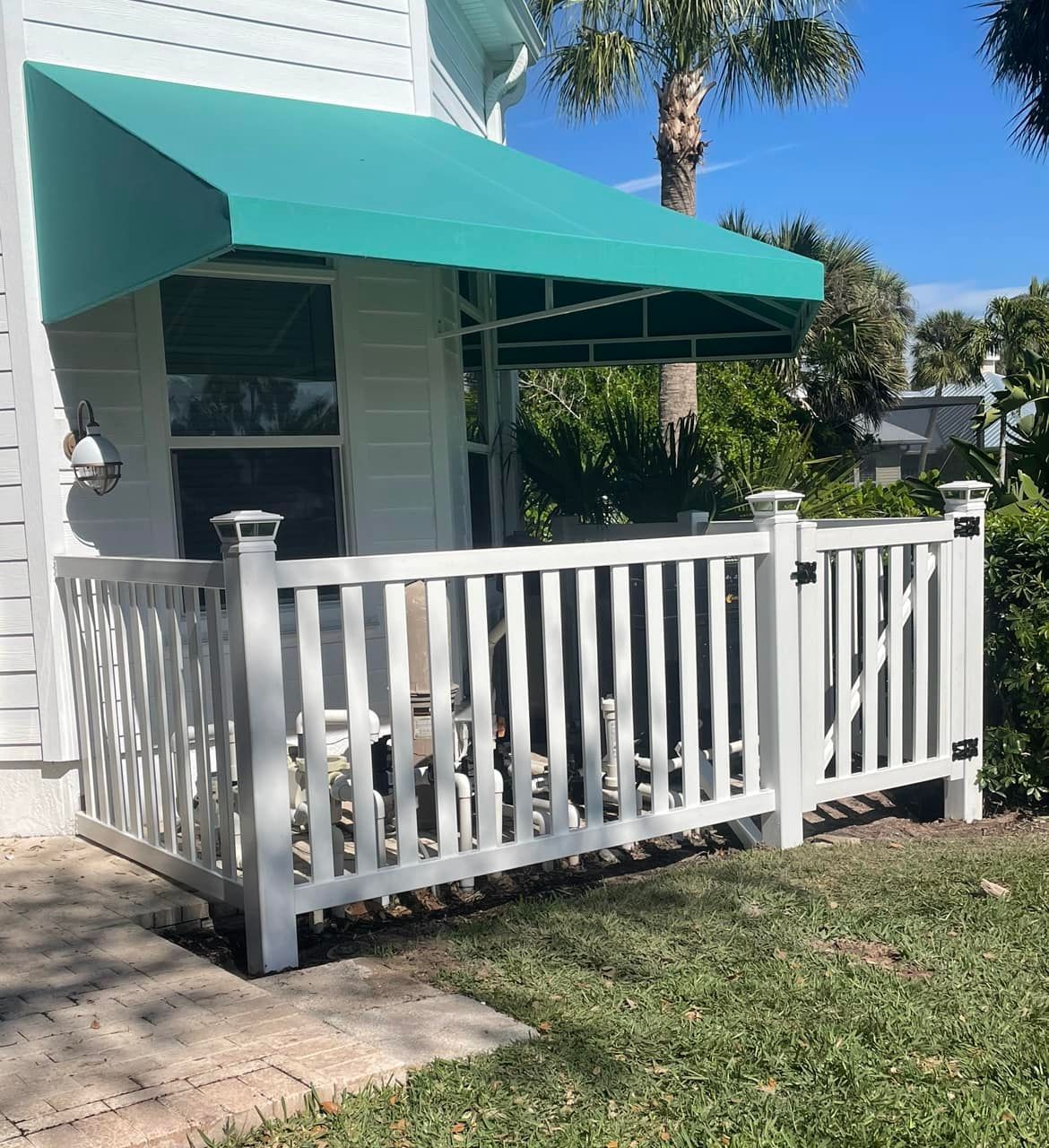 A white house with a green awning over the porch