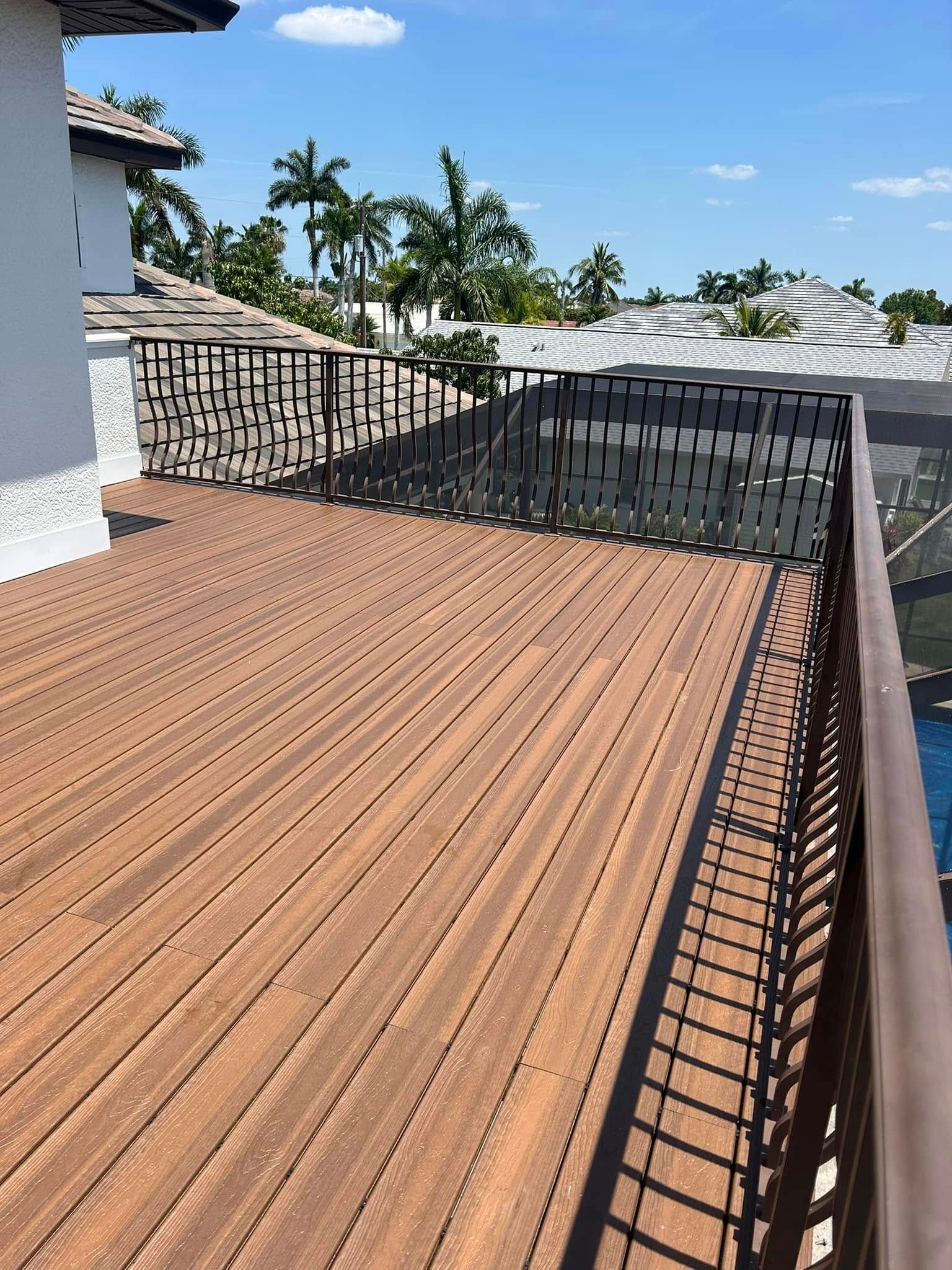 A wooden deck with a metal railing overlooking a body of water.