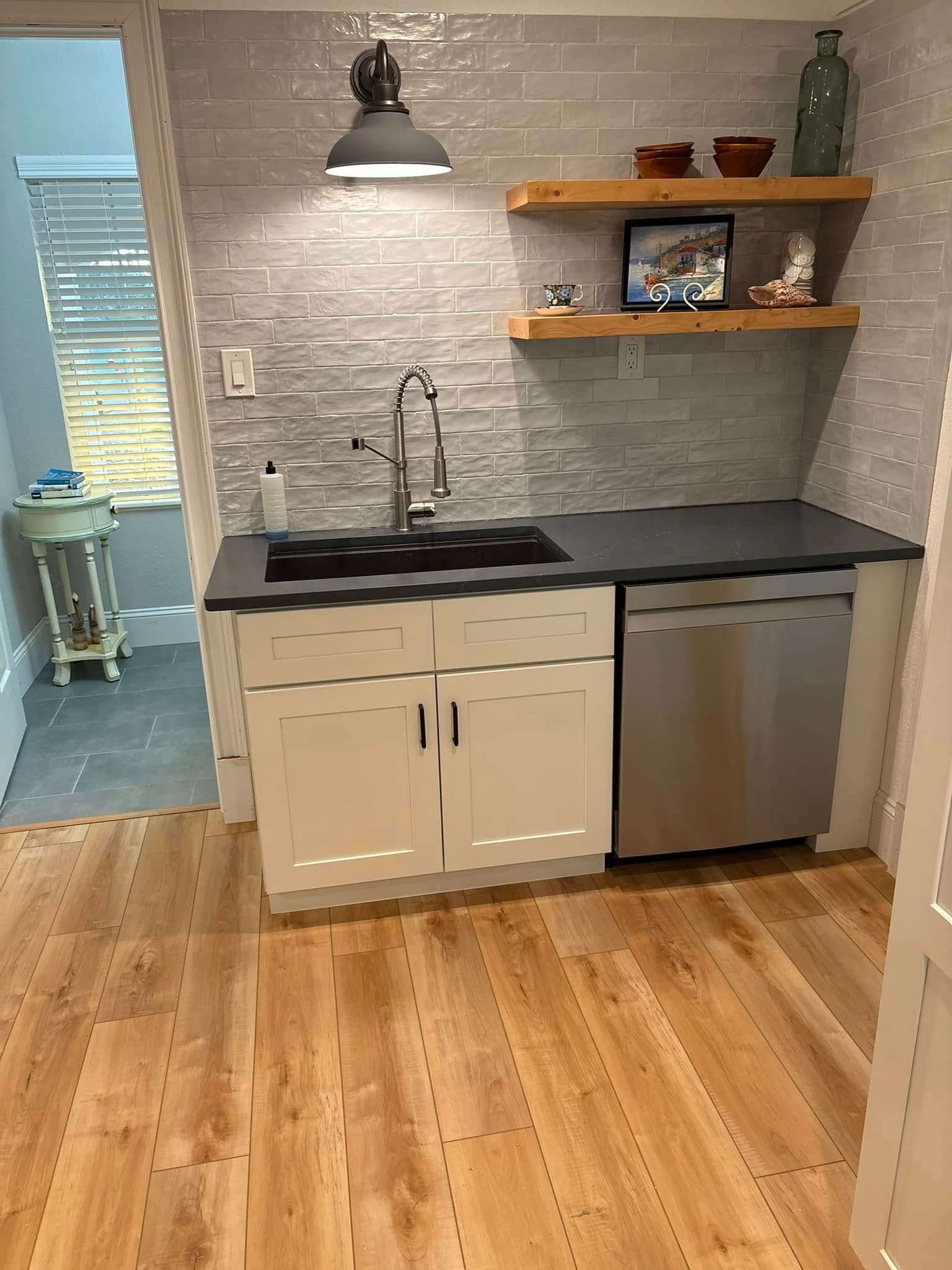 A kitchen with a sink , dishwasher , and stainless steel appliances.