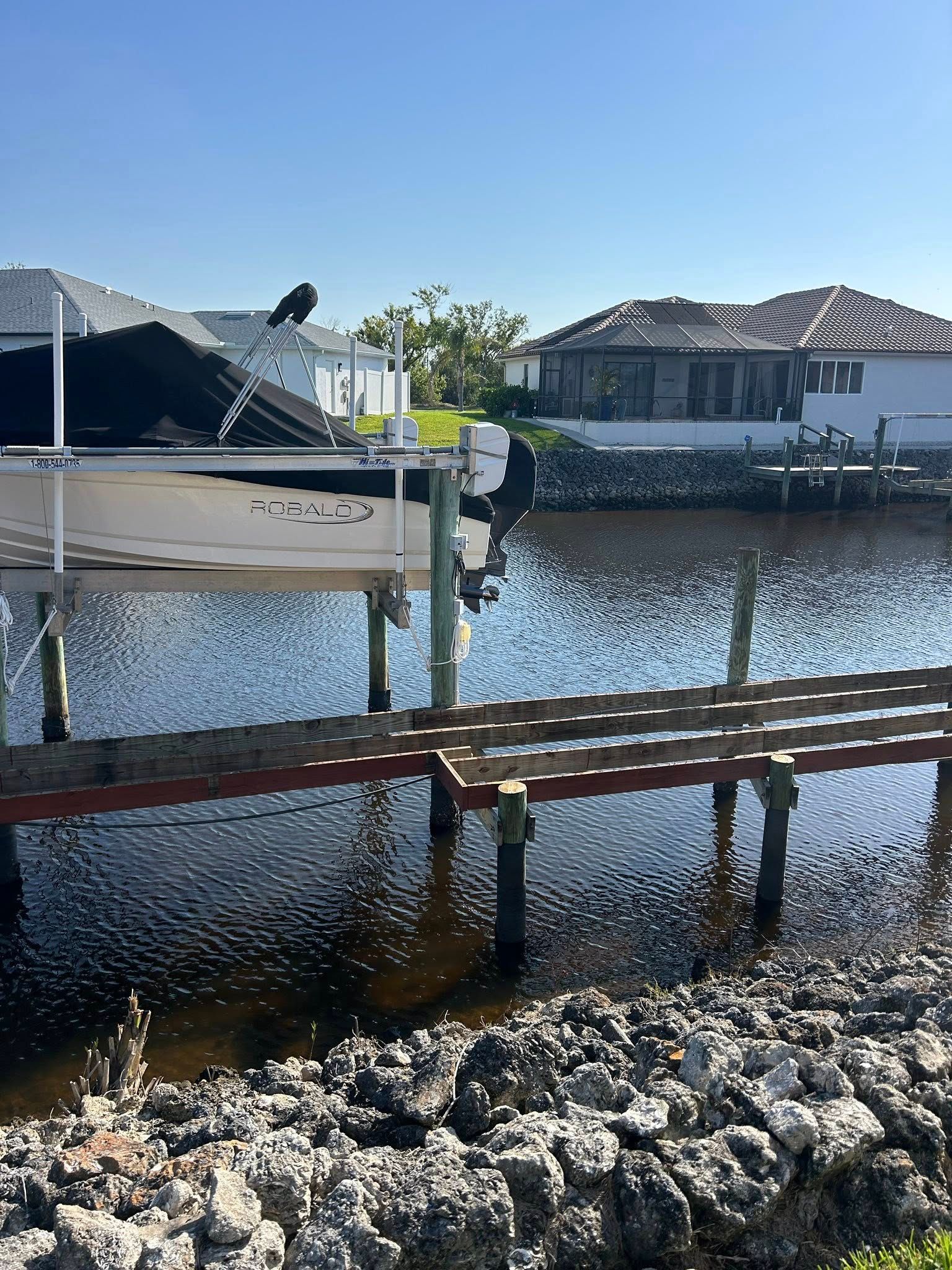 A boat is docked on a dock in the water near a house.