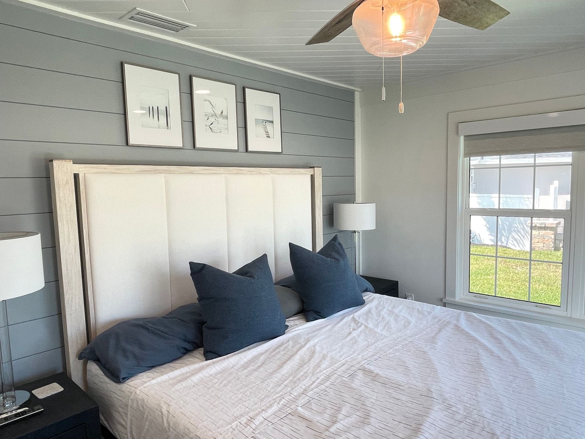 A bedroom with a large bed and a ceiling fan.