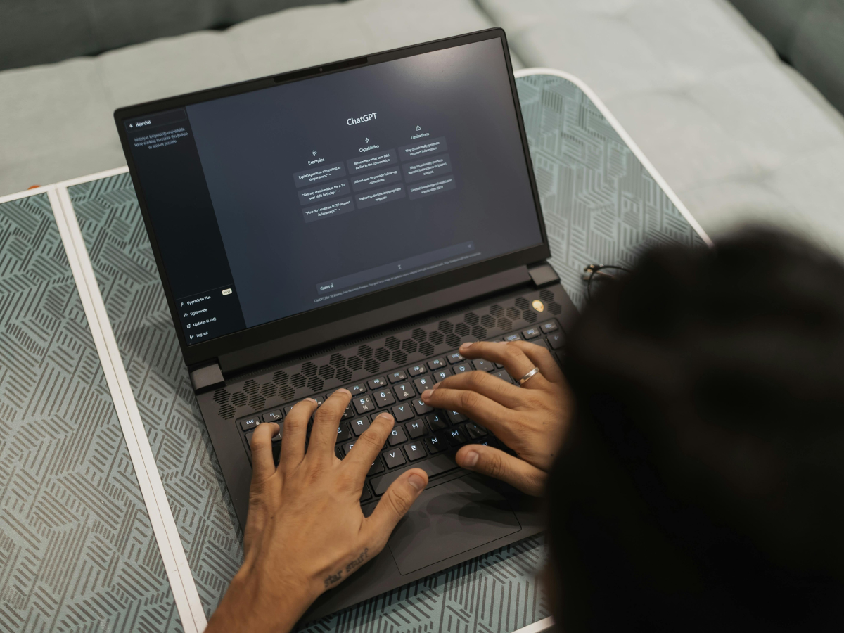 A person is typing on a laptop computer on a table.