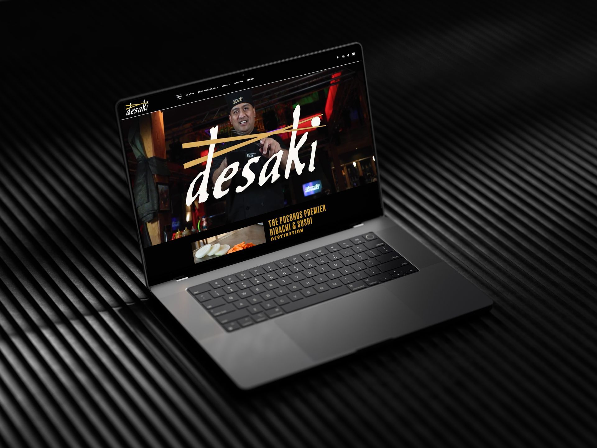 A laptop computer is open to a website called desaki.