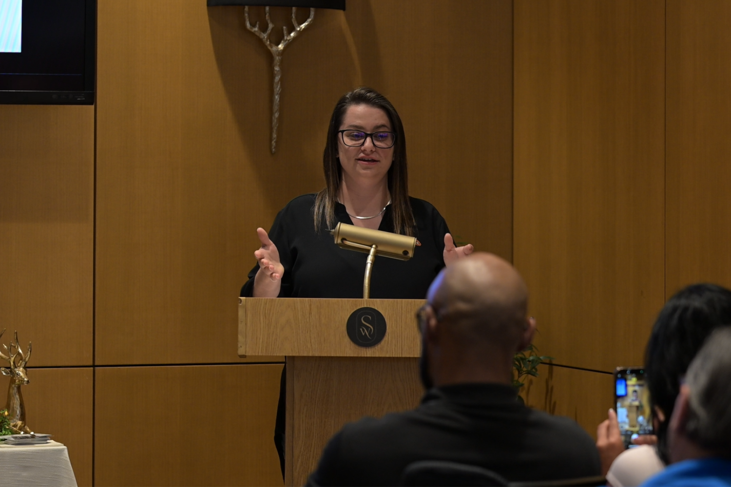 Courtney giving a speech at a business event