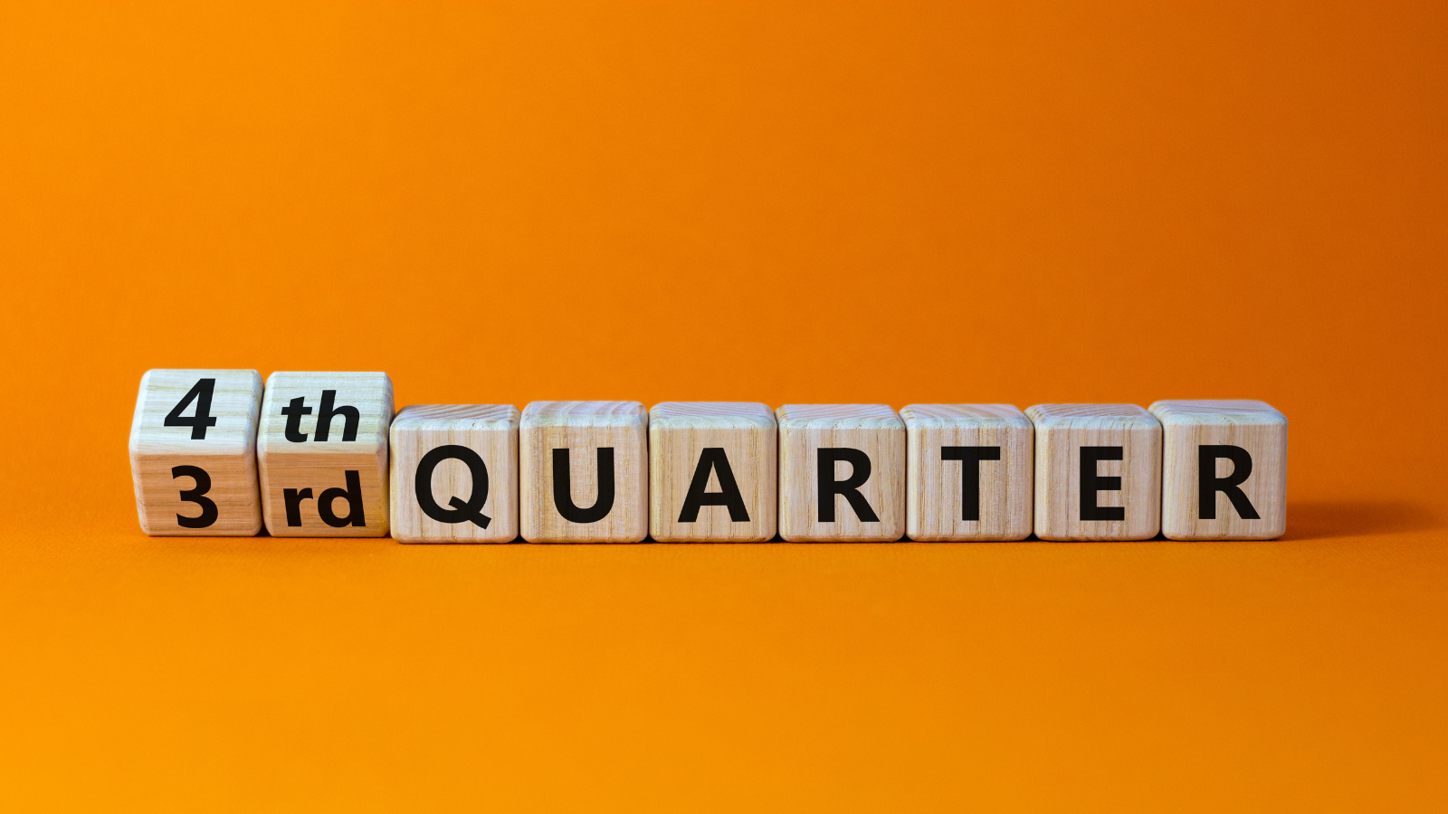 The word quarter is written on wooden blocks on an orange background.