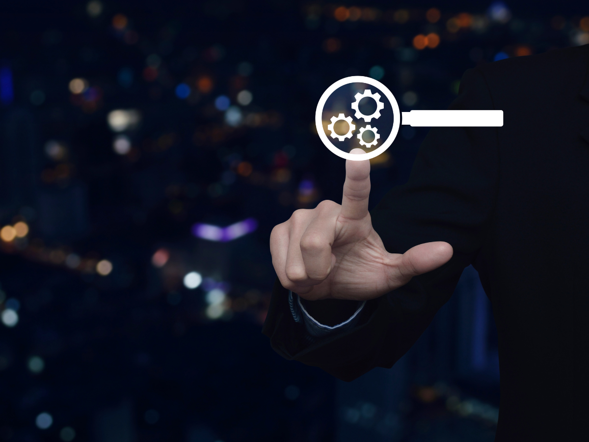 A person is pointing at a magnifyiLearn what Generative Engine Optimizationg glass with gears in it.