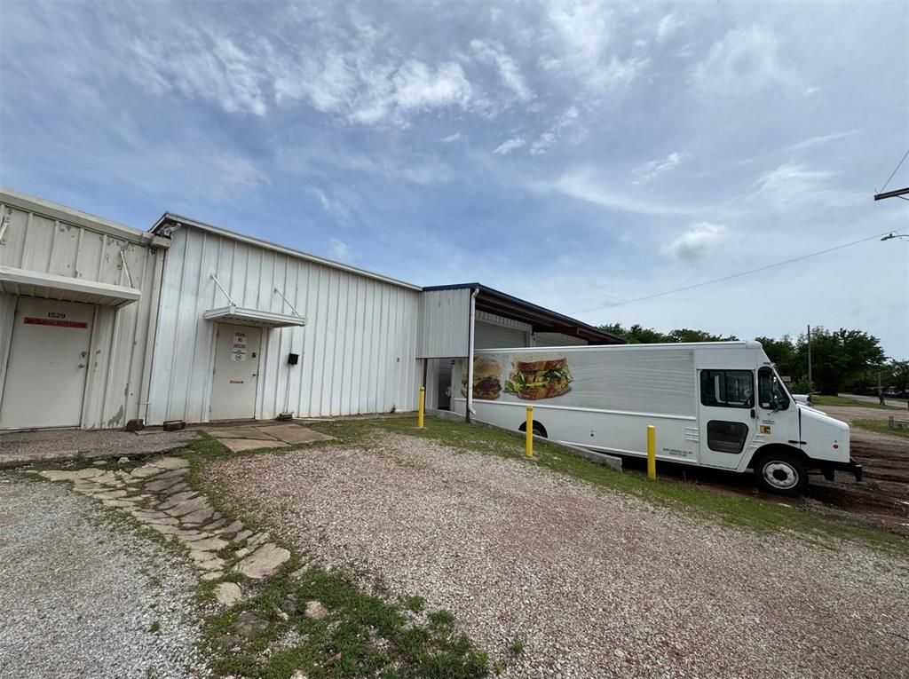 A white truck is parked in front of a white building.
