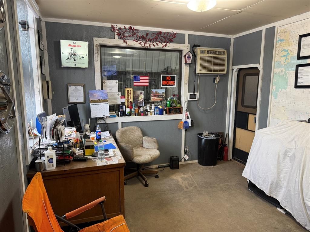 A room with a desk, chair, and a bed.