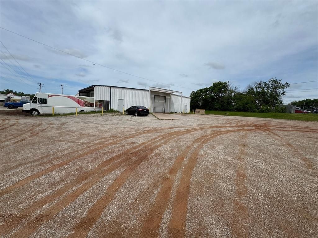 A large white building with a dumpster in front of it.