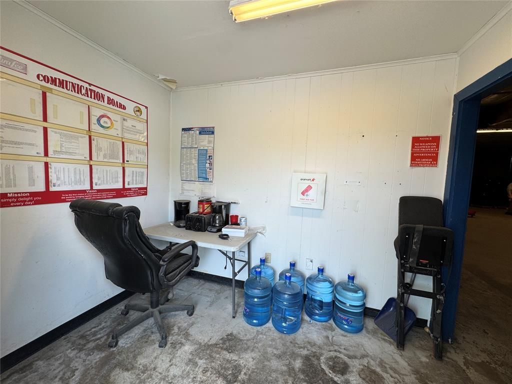 A room with a chair, table, and water bottles.