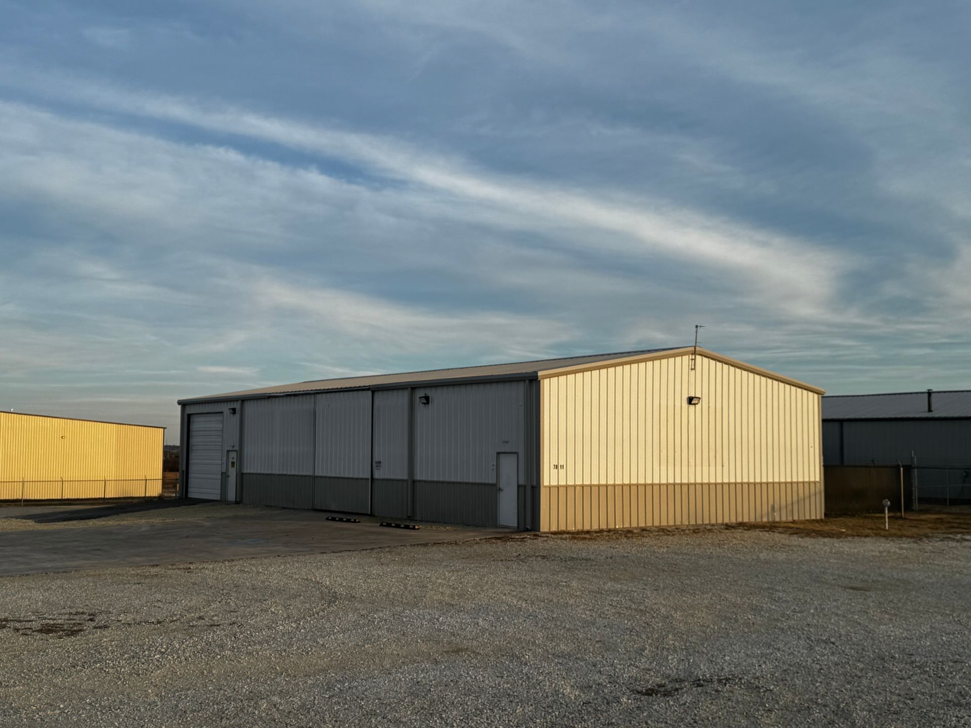 A large white building with a truck parked in front of it.