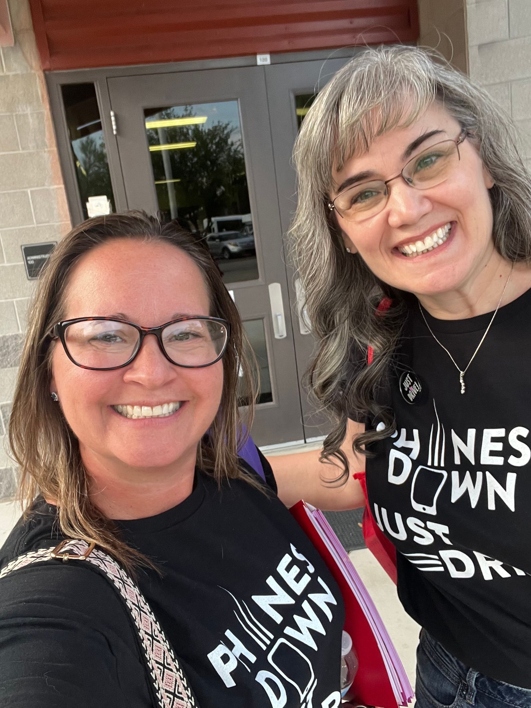 Two women smile, wearing black