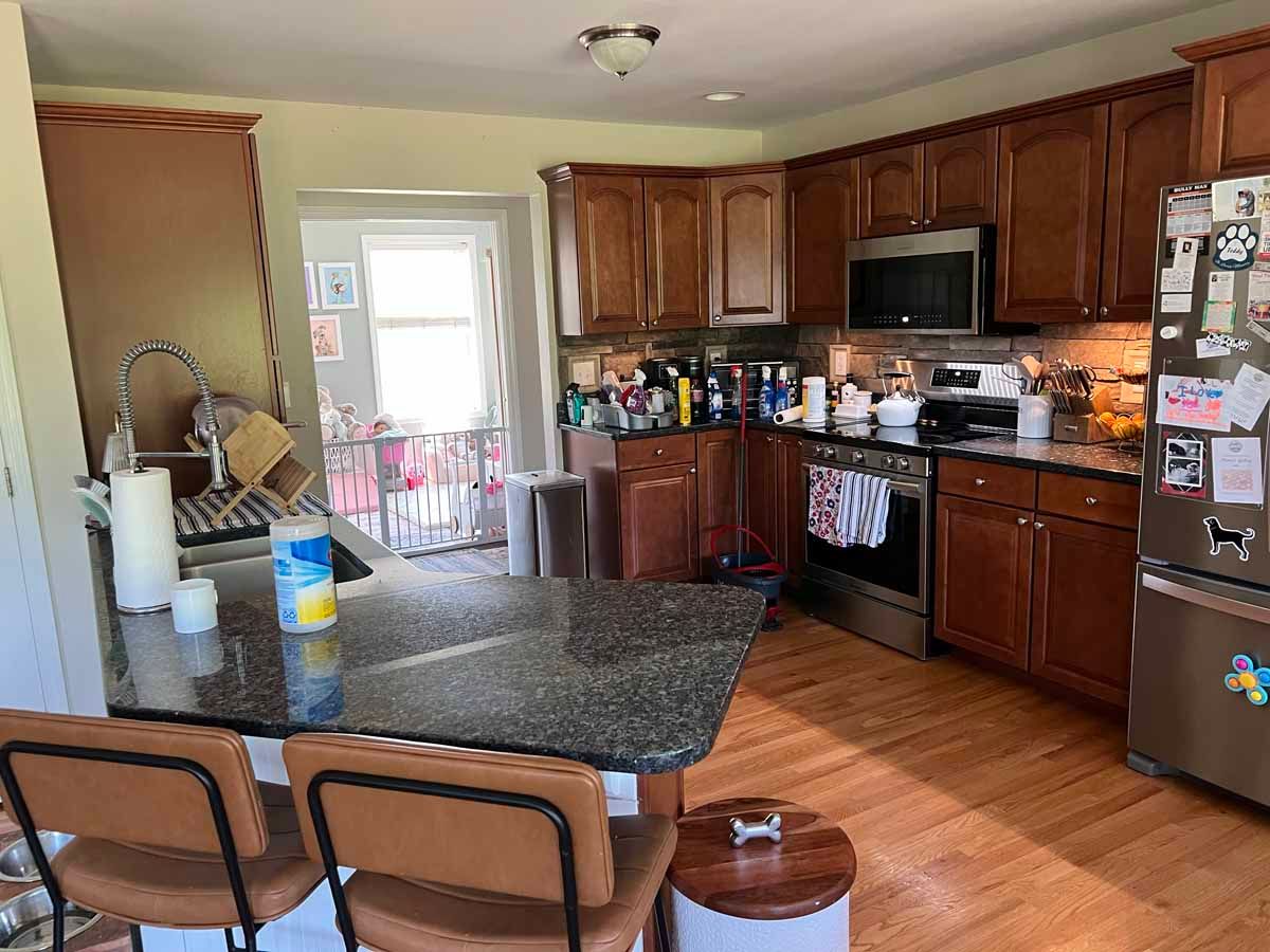 Kitchen with wood cabinets, granite countertop island, stainless steel appliances, and a doorway.