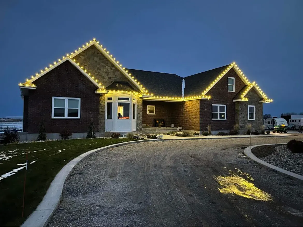 A large brick house with christmas lights on the roof