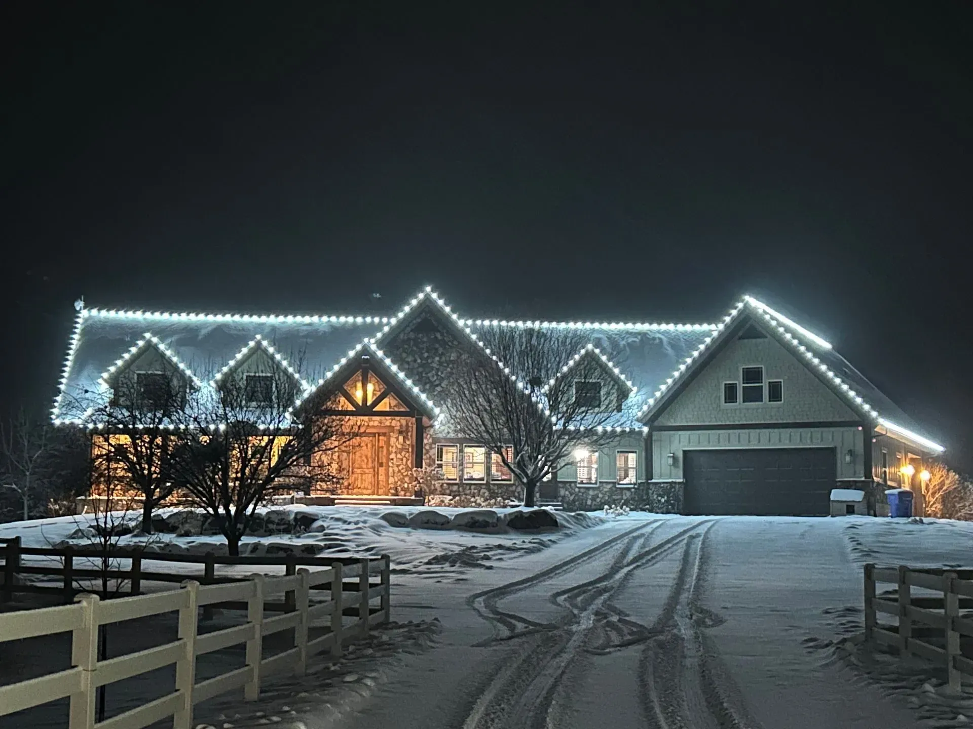 A house with christmas lights on the roof at night