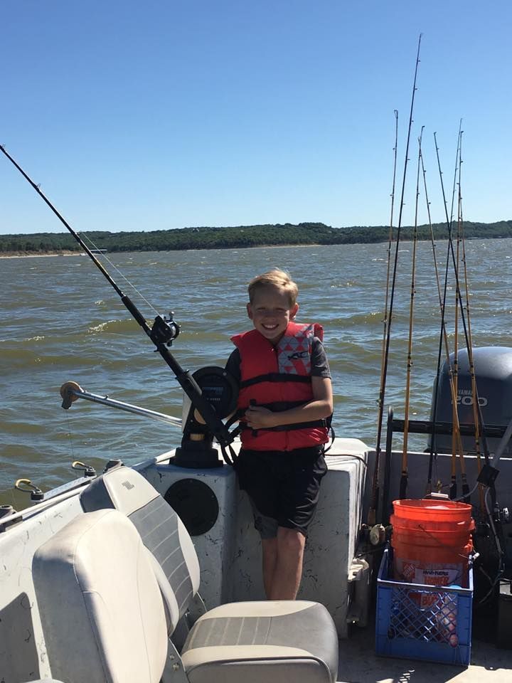 young-boy-holding-fishing-rod-standing-on-fishing-boat