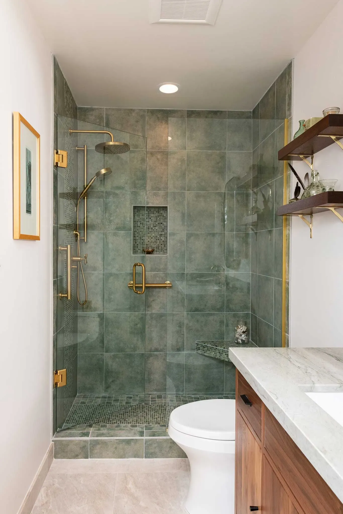 A bathroom with a toilet , sink and walk in shower.