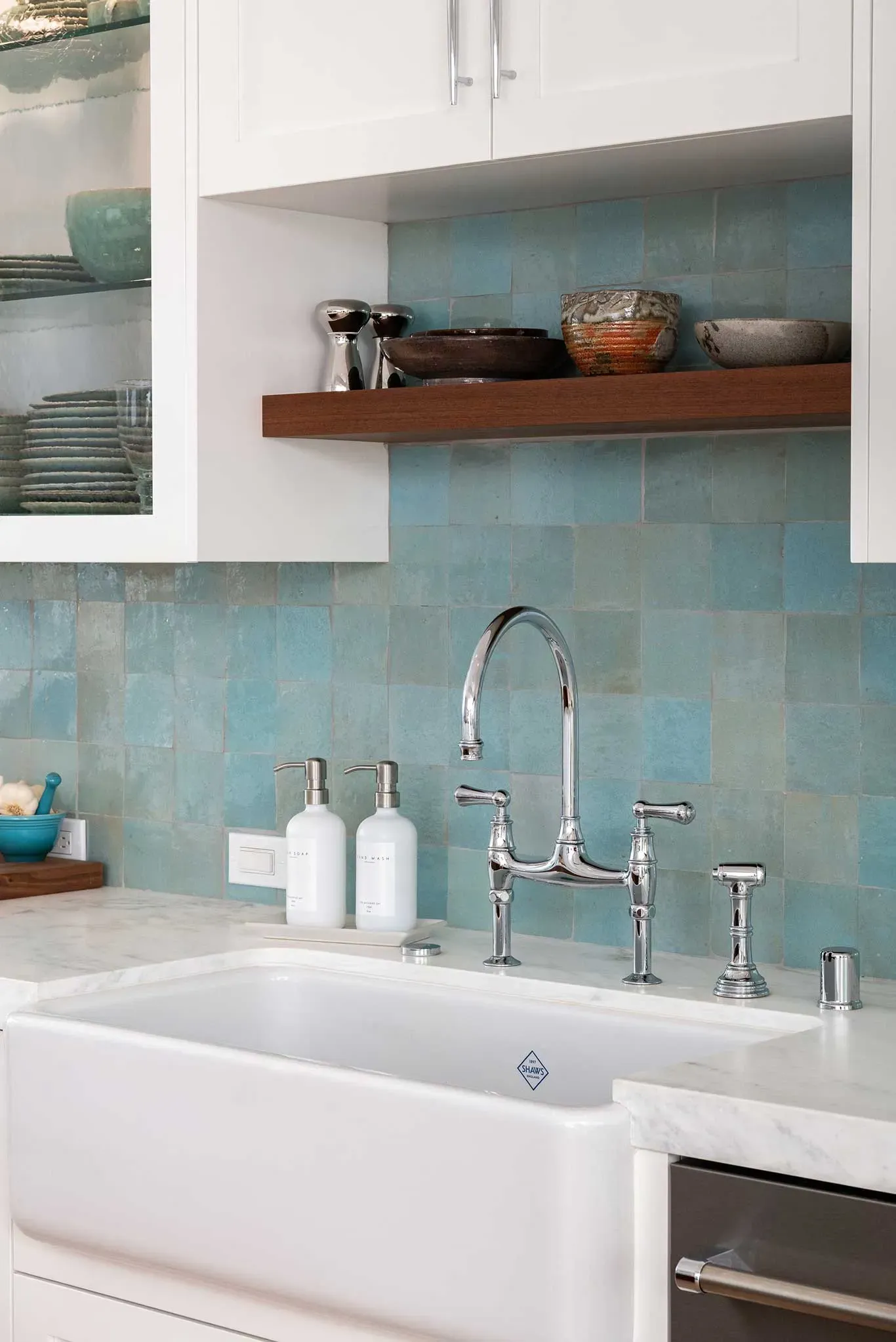 A kitchen with a white sink and a blue wall