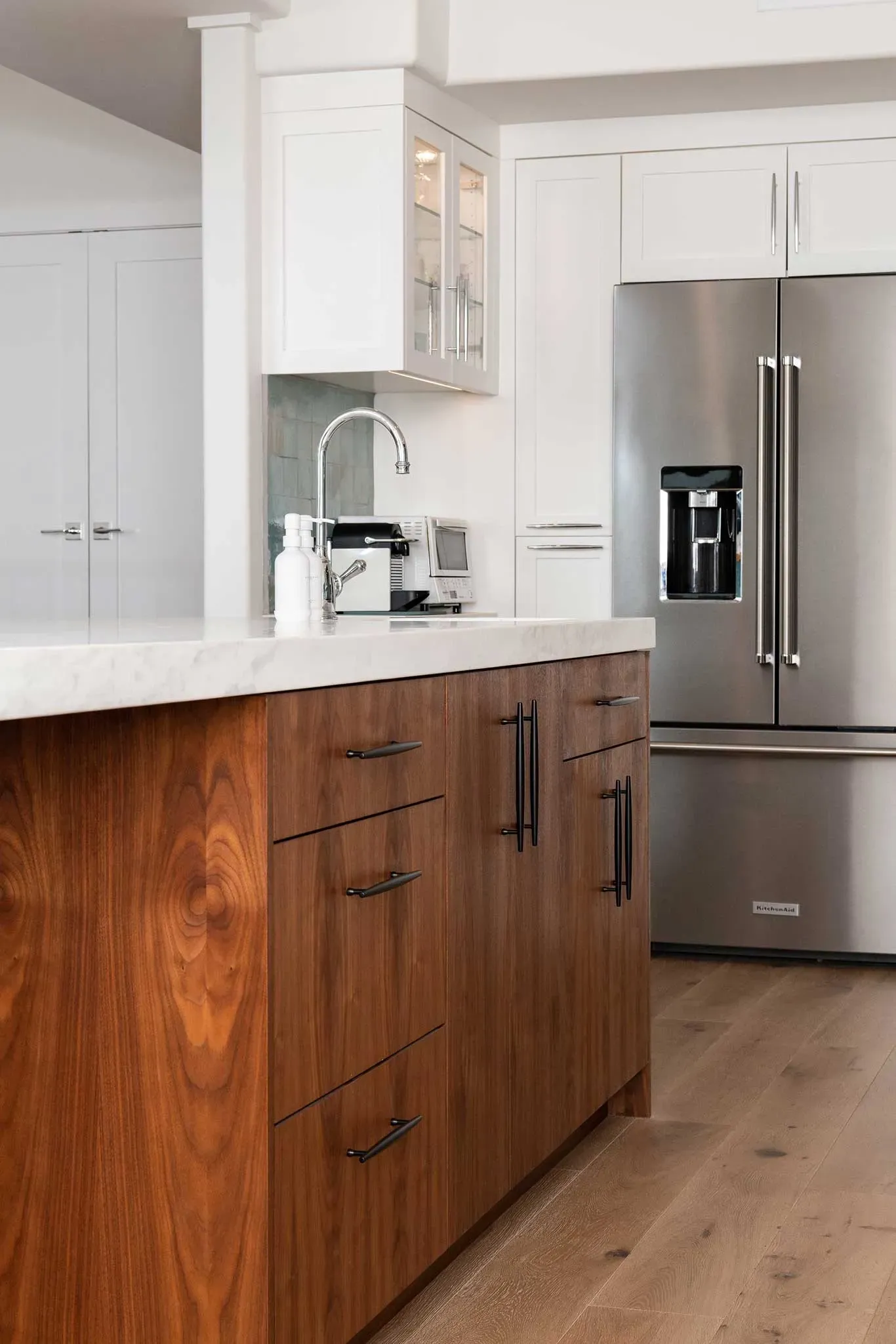 A kitchen with wooden cabinets and a stainless steel refrigerator
