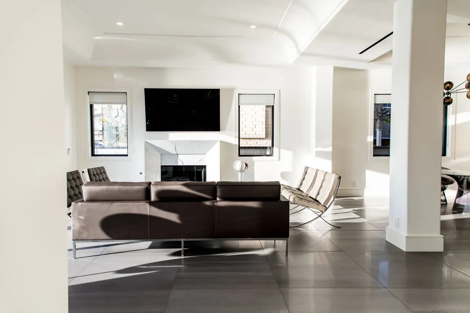 A living room with a couch , chairs , television and fireplace.