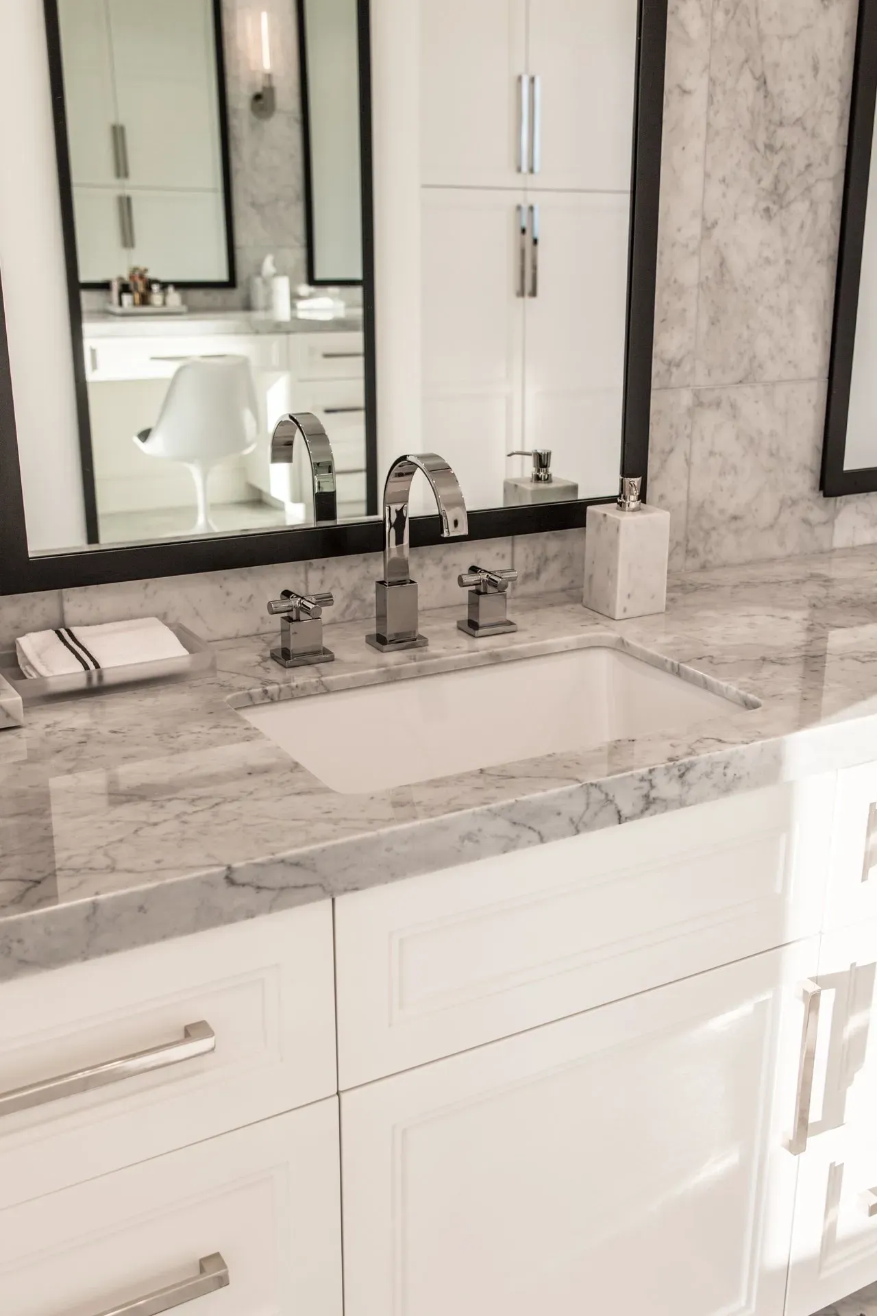 A bathroom with a sink and two mirrors.