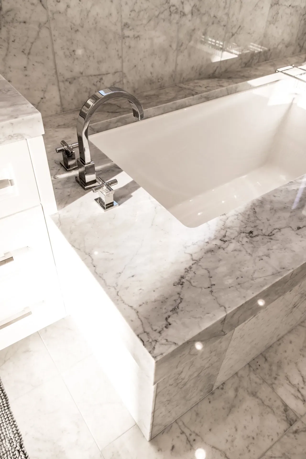 A bathtub in a bathroom with a marble counter top