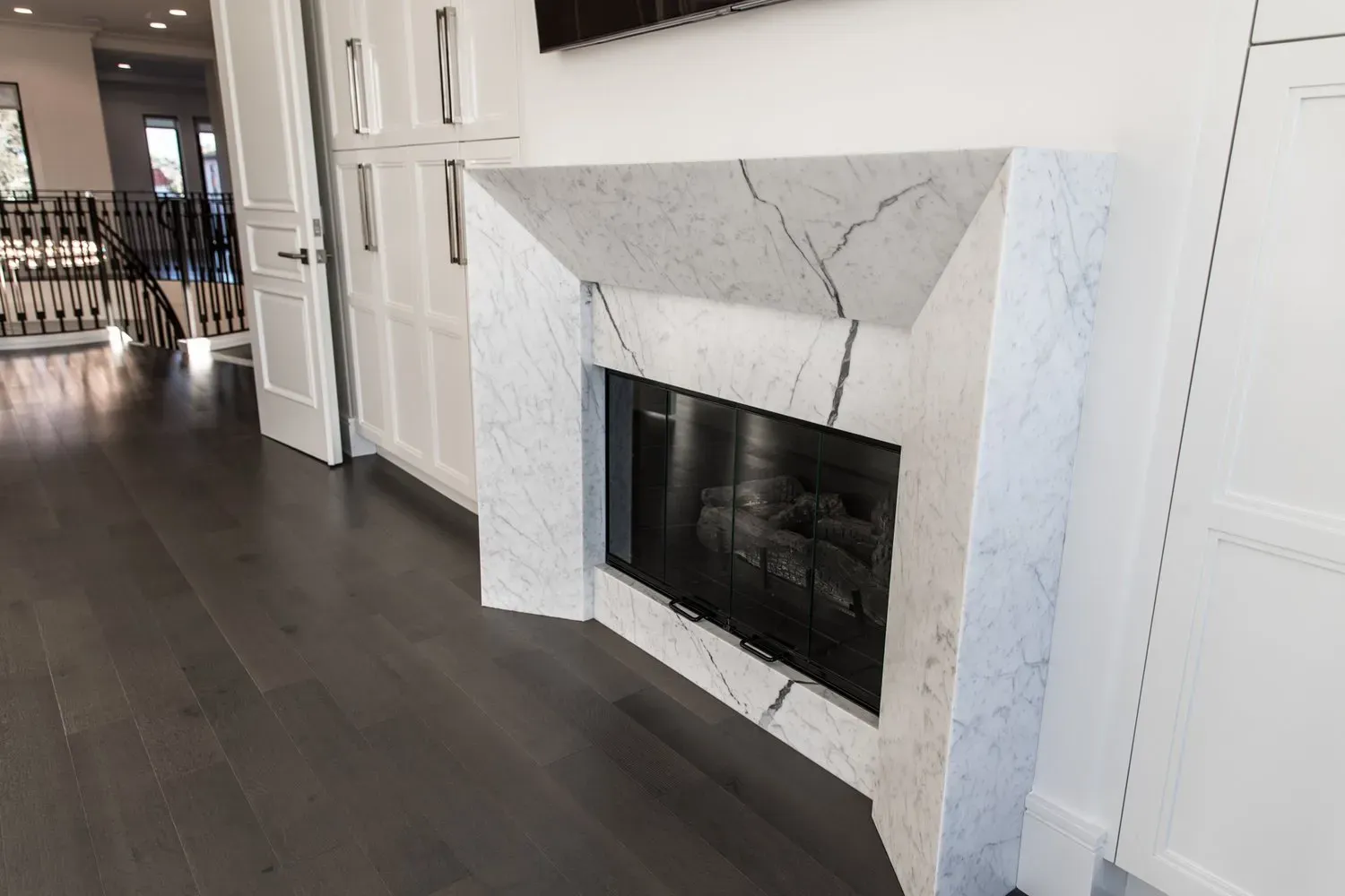 A fireplace with a marble mantle in a living room.
