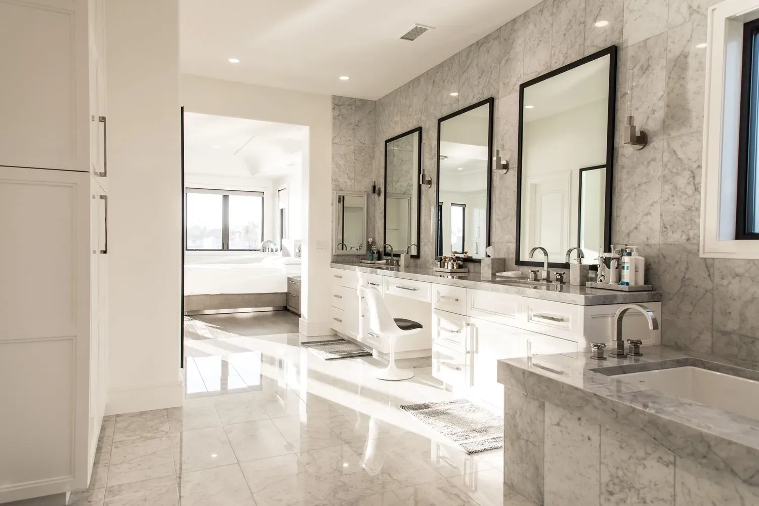 A bathroom with two sinks , two mirrors and a tub.