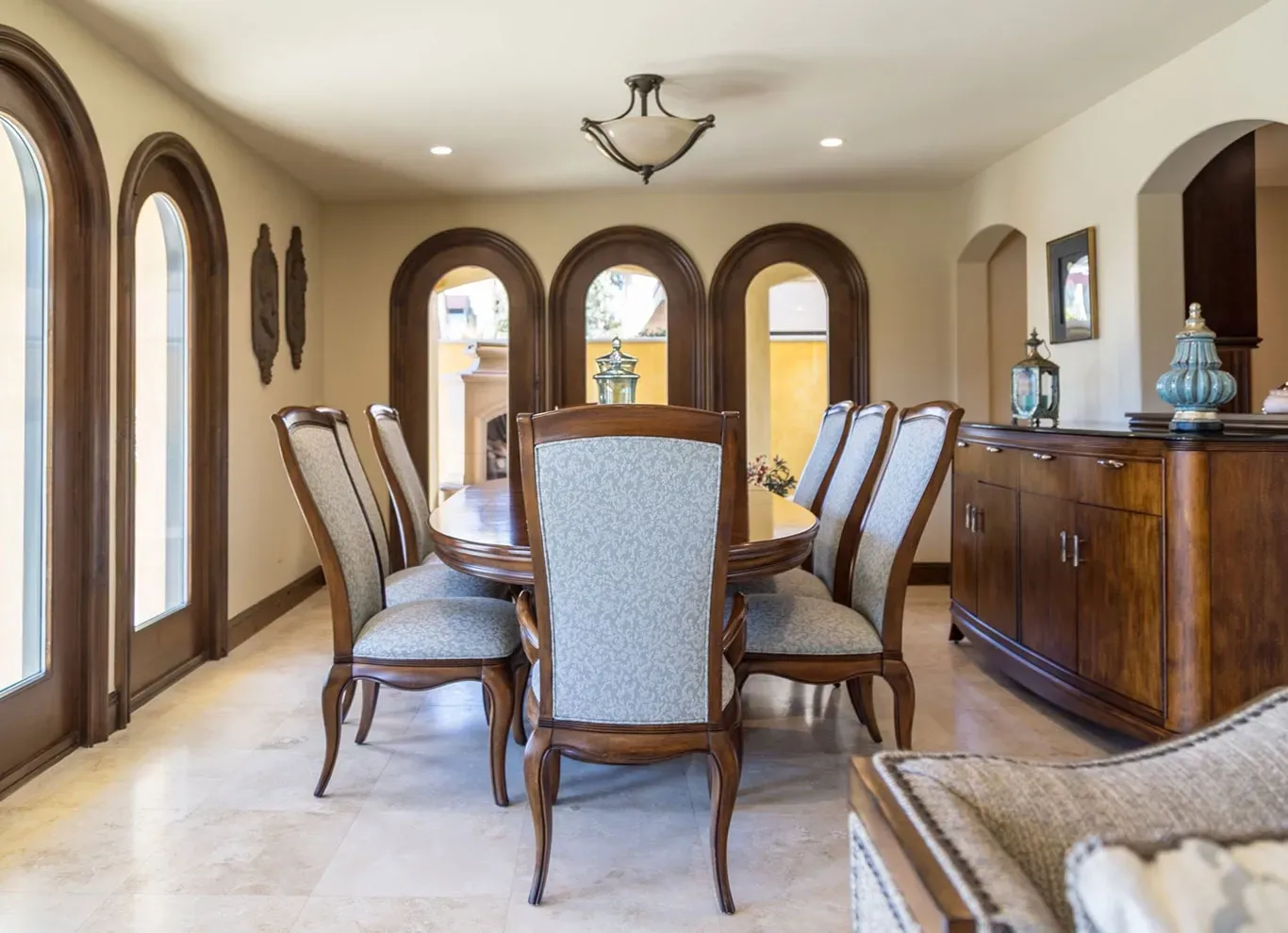 A dining room with a table and chairs and a dresser.