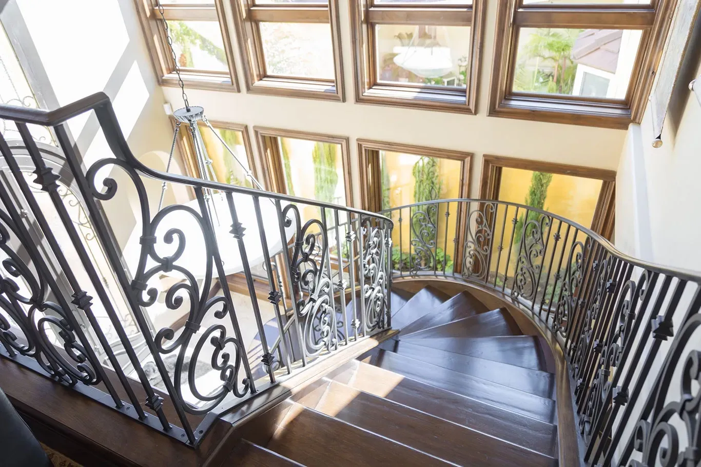 A spiral staircase with a wrought iron railing in a house.