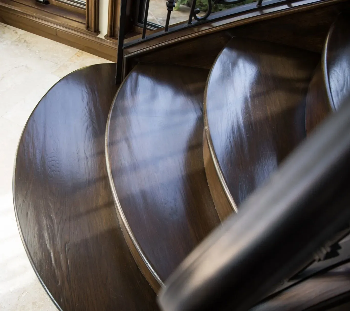 A wooden spiral staircase with a metal railing