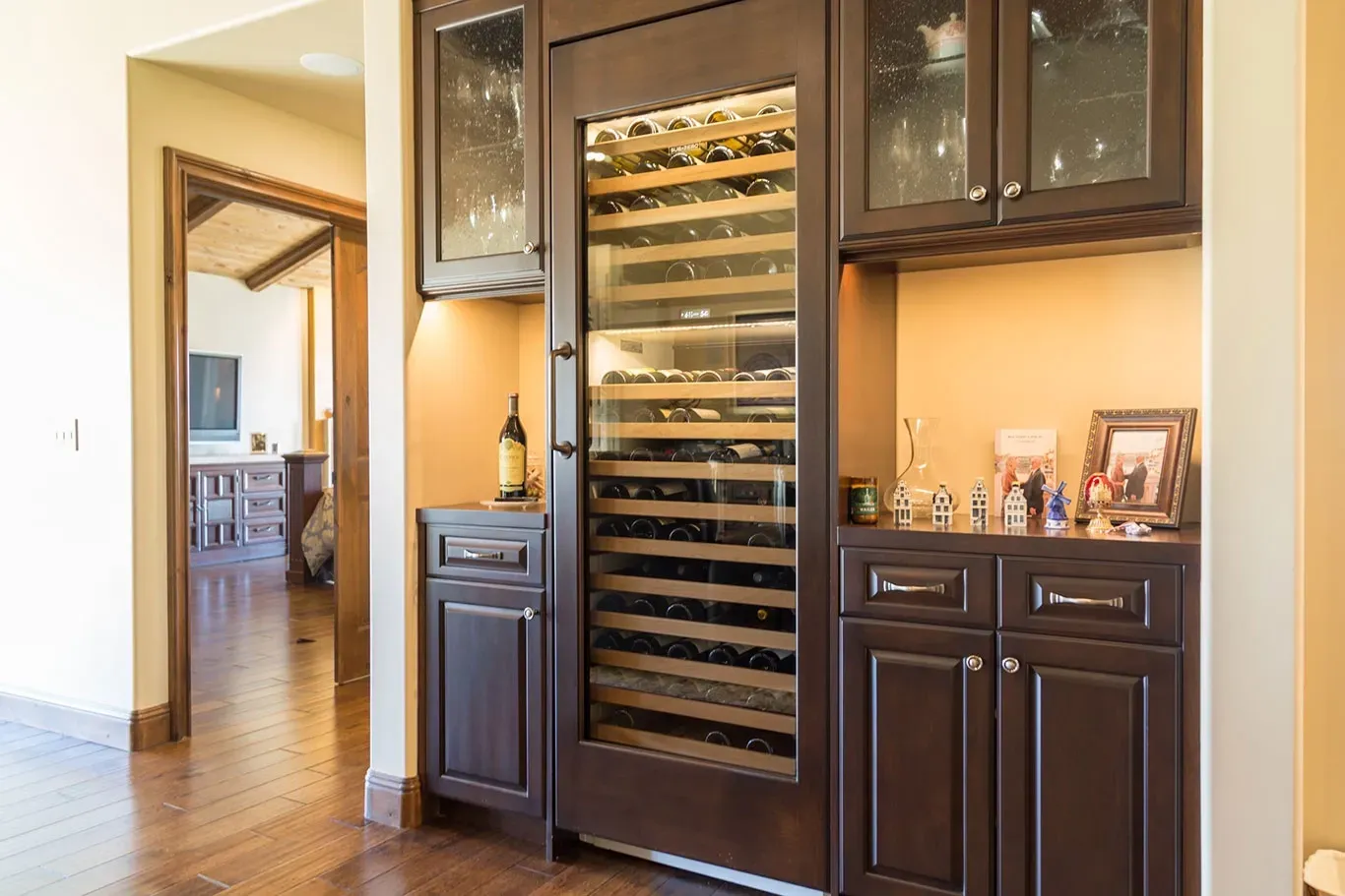 A wine cooler is built into the wall of a kitchen.