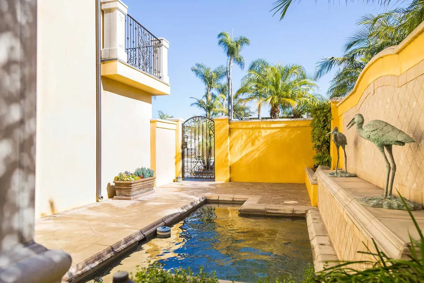 There is a swimming pool in the backyard of a house.