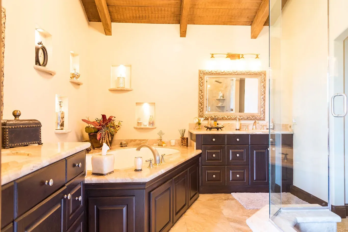 A bathroom with two sinks , a tub , and a walk in shower.